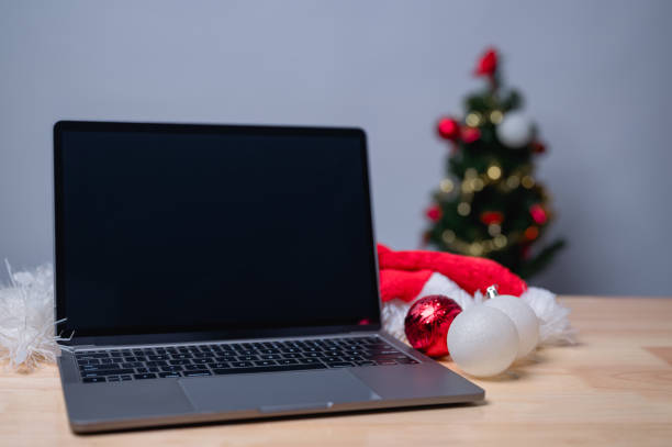 istock This festive scene features a laptop alongside Christmas decorations, including ornaments and a Santa hat, creating a joyful atmosphere perfect for holiday productivity or relaxation 2184422958