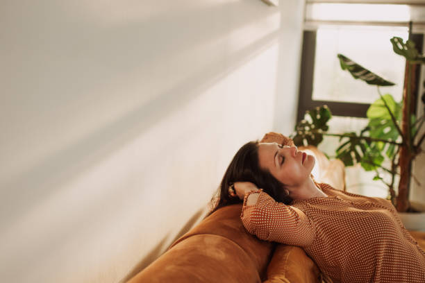istock Woman Relaxing on Sofa in Sunlit Living Room Environment 2184423342