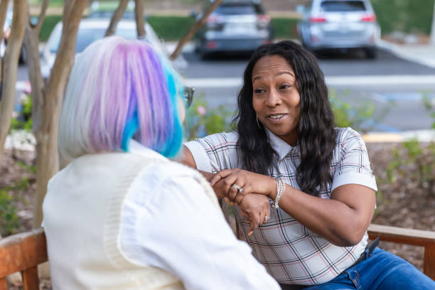istock Two women having a deep conversation on a park bench 2184423514