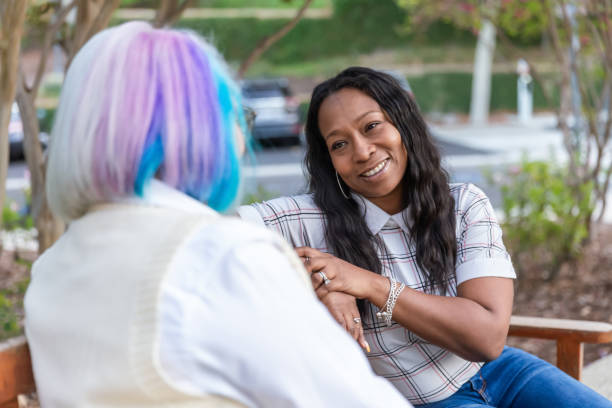 istock Two women having a deep conversation on a park bench 2184423548