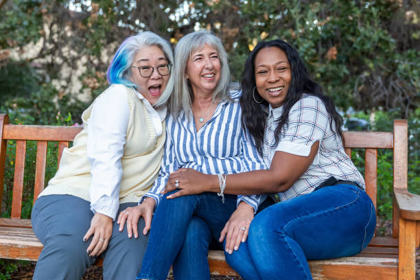 istock Three older best friends laughing on a bench 2184423841