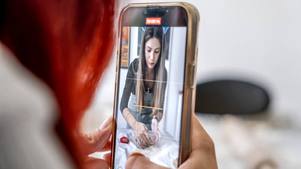 istock In an art studio with an environment adorned with artistic paintings in the background, a beautiful middle-aged woman artist is shaping clay at a table, while a young woman next to her is taking a photo with her phone 2184423849