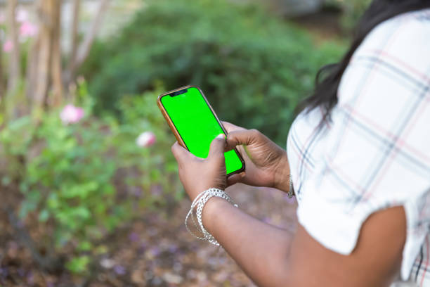 istock Woman outside on phone with green screen 2184424757