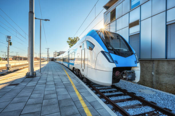 istock High-speed blue passenger train at railway station platform under clear blue sky at sunset. Train station. Modern railway transportation concept. Railroad. Commercial. Urban rail transport in Slovenia 2184427115