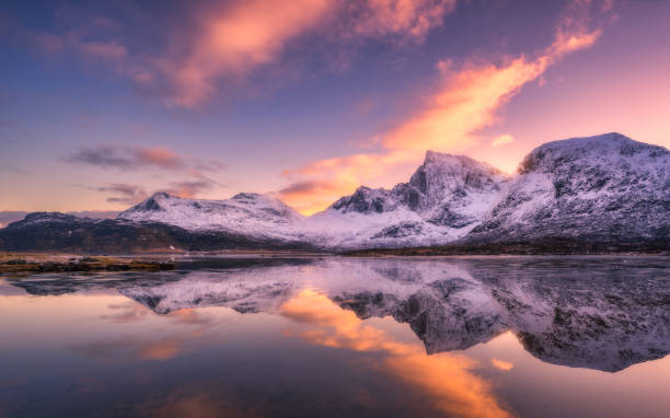 istock Beautiful snowy mountains and colorful sky with clouds at sunset 2184427468