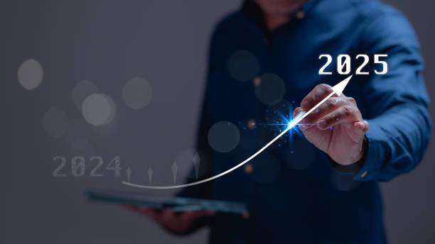 istock A man is pointing a graph on a tablet with a blue shirt. The graph shows a line that is rising to the right, with the number 2025 at the top. Concept of progress and growth 2184428041