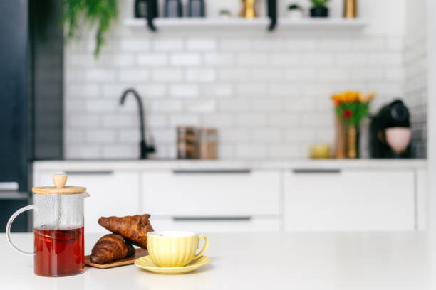 istock A cozy breakfast setup with tea, croissants, and a yellow cup in a modern kitchen 2184428491