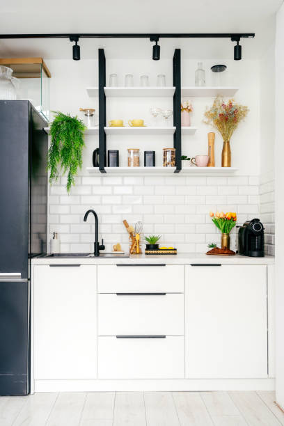 istock Modern kitchen with white cabinets, black accents, and vibrant plants 2184428554