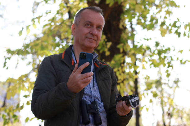 istock Mature man in adventure in nature using phone 2184428663