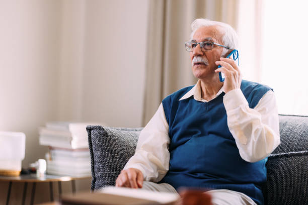 istock Elderly Man Engaged in Phone Conversation Sitting at Home 2184430164