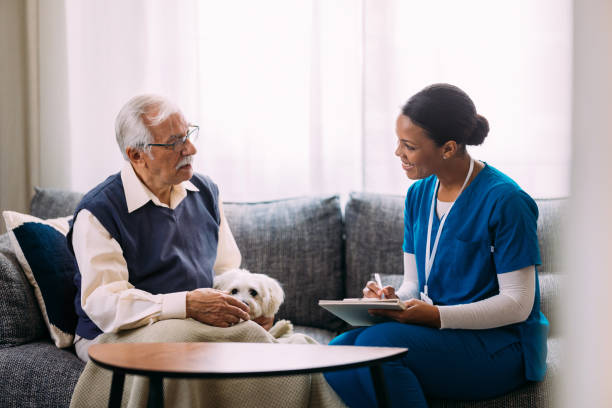 istock Caring Nurse Visits Elderly Man At Home With Pet Dog 2184430203