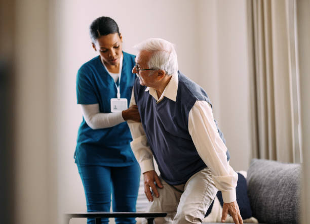 istock Caring Nurse Assisting Elderly Man in Rehabilitation at Home 2184430210