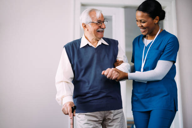istock Happy Caregiver Assisting Elderly Man with Walking at Home 2184430218
