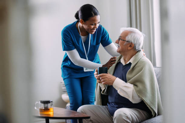 istock Caring Nurse Assisting Elderly Man at Home with Warm Smile 2184430235