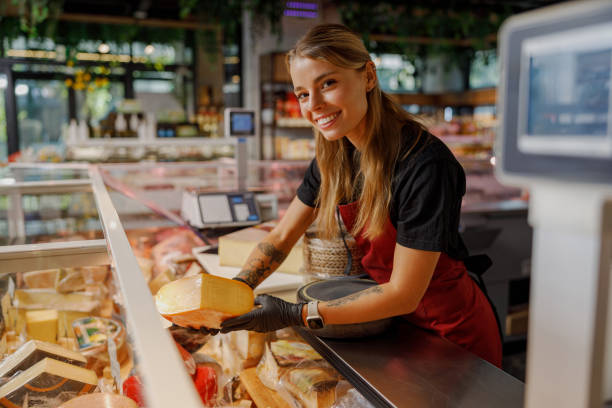 istock A cheerful employee at a cheese shop is enthusiastically smiling while serving happy customers 2184431759