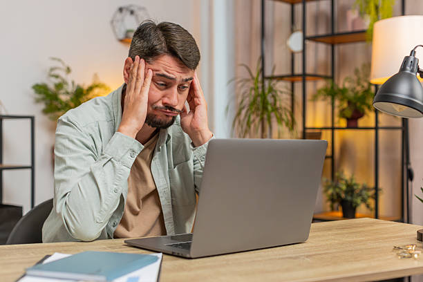 istock Angry furious man freelancer using laptop working at home office having nervous breakdown at work 2184436357