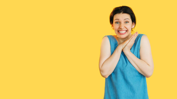 istock Excited Woman in Blue on Bright Yellow Background 2184436556