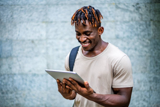 istock Joyful Black Man Engaging with Digital Tablet Outdoors 2184439078