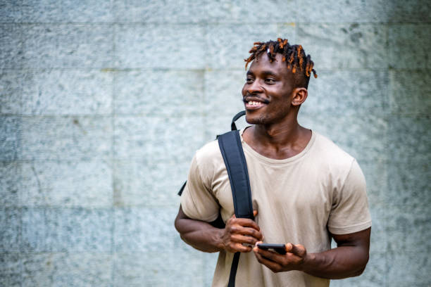 Joyful Black Man Engaging with Smartphone Outdoors