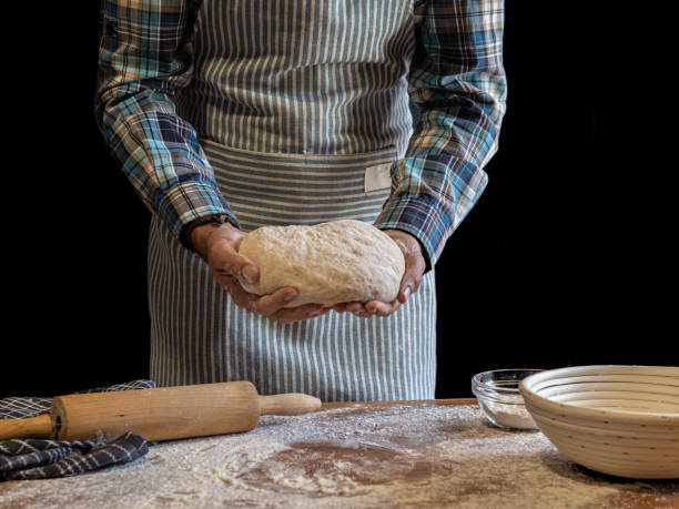 istock Baker making artisan bread. Bakery utensils. Black background. black and white photo 2184440159