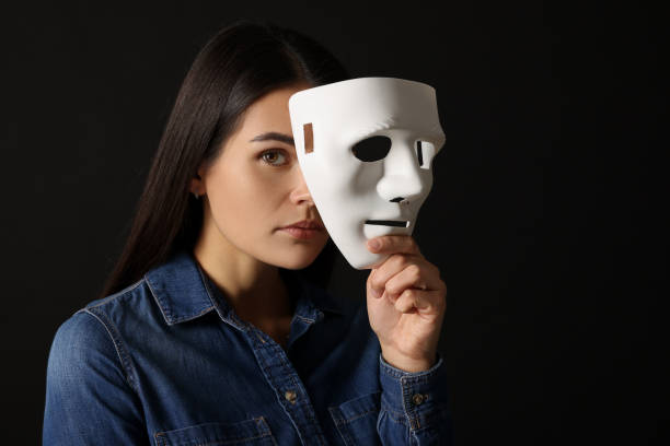 istock Multiple personality concept. Woman with mask on black background, space for text 2184451029