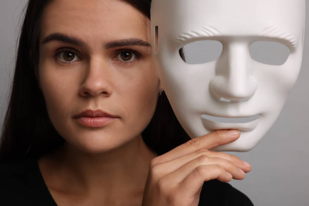 istock Multiple personality concept. Woman with mask on grey background 2184451082