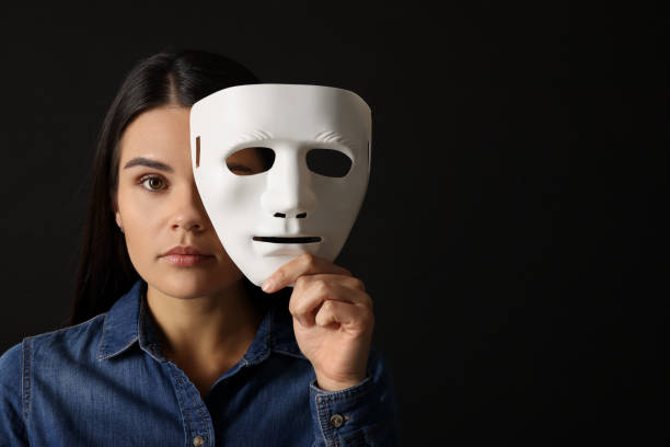 istock Multiple personality concept. Woman with mask on black background, space for text 2184451124