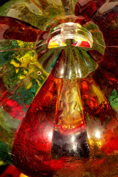 Colorful glass hummingbird feeder with cool morning sun flowing through it.