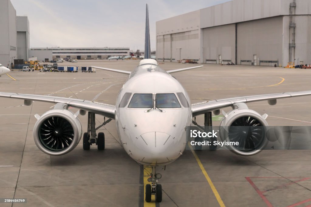 Front view of a modern twinjet airliner sitting on the concrete tarmac with lane markings in a large airport Front view of a modern twinjet airliner sitting on the concrete tarmac with lane markings in a large airport. Commercial Airplane Stock Photo Front view of a modern twinjet airliner sitting on the concrete tarmac with lane markings in a large airport Front view of a modern twinjet airliner sitting on the concrete tarmac with lane markings in a large airport. Commercial Airplane Stock Photo