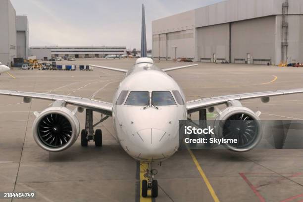 Front View Of A Modern Twinjet Airliner Sitting On The Concrete Tarmac With Lane Markings In A Large Airport Stock Photo - Download Image Now