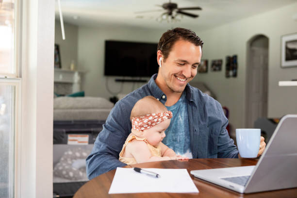 istock Smiling businessman cares for daughter while participating in video call 2184457329