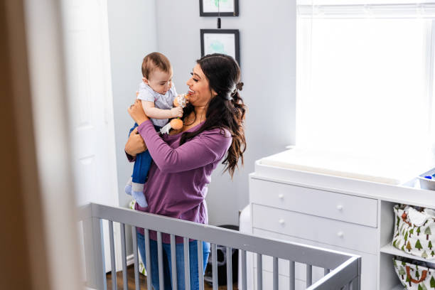 istock Young mom prepares to put son down for a nap 2184457348