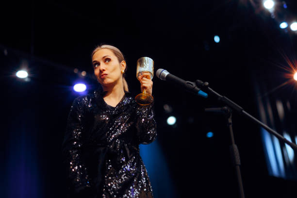 istock Woman Toasting with a Glass on Stage Celebrating 2184457871
