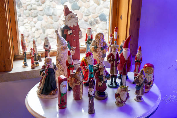 This image shows a small side table decorated with an assortment of various vintage Christmas Santa Claus figurines.