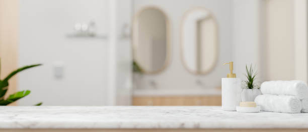 istock A white marble tabletop, set against a blurred background of an elegant white bathroom. 2184460096