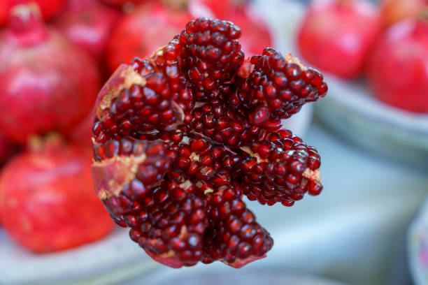 A close up of a red pomegranate with a few seeds visible in Tashkent, Uzbekistan