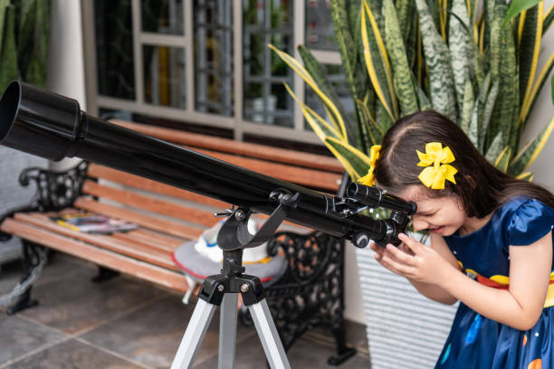 istock Girl looking through a telescope in an outdoor setting 2184462990