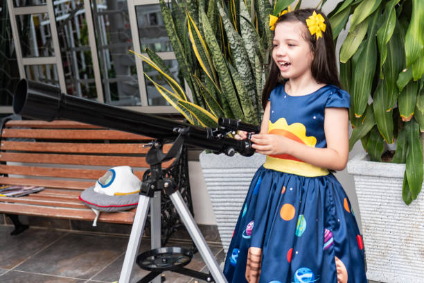 istock Excited girl holding a telescope in a backyard 2184463002