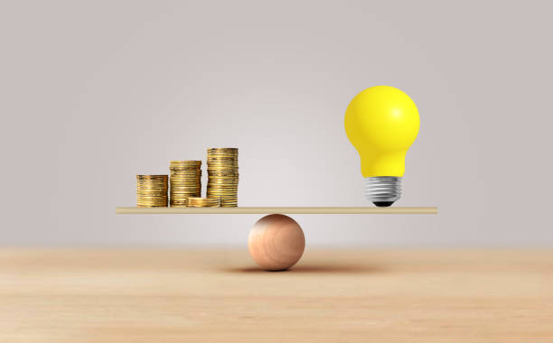 istock Light bulb and coins stacked balancing scale, investment in ideas. Inspiration concept 2184468943