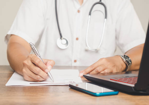 istock Doctor writing medical notes on patient records. 2184473341