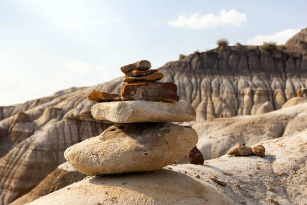 Stack of bright orange and sandy balancing rocks in the scenic badlands, eroded formations in canyon. Hoodoos trail, Drumheller, Alberta, Canada.