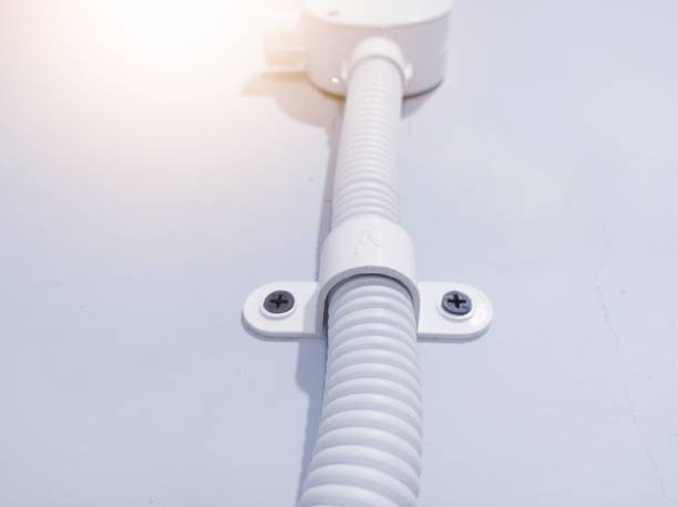 istock Installation flexible pipe for electric cable with clamp on the wall. 2184477869