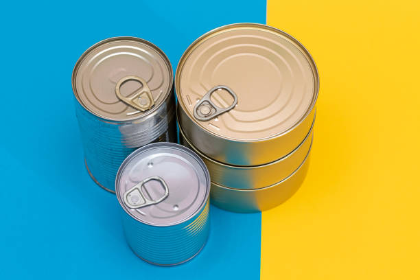 istock A Group of Stacked Tin Cans on Split Blue and Yellow Background 2184482655
