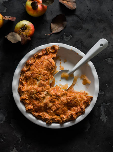 istock Traditional Irish apple pie in a baking dish, apples on a dark background, top view 2184486836