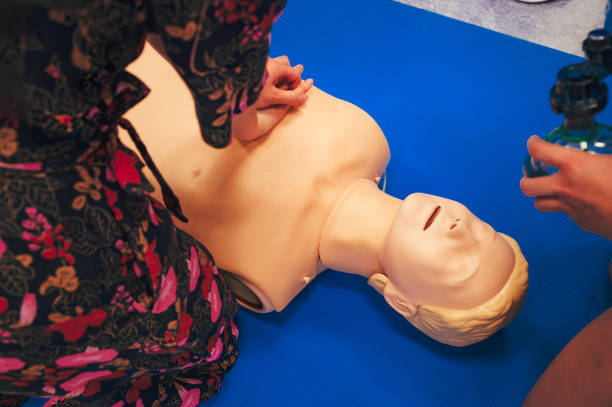 Medical Students Practicing CPR Chest Compressions on a Human Figure Lying on the Ground During a Life-saving Training Session