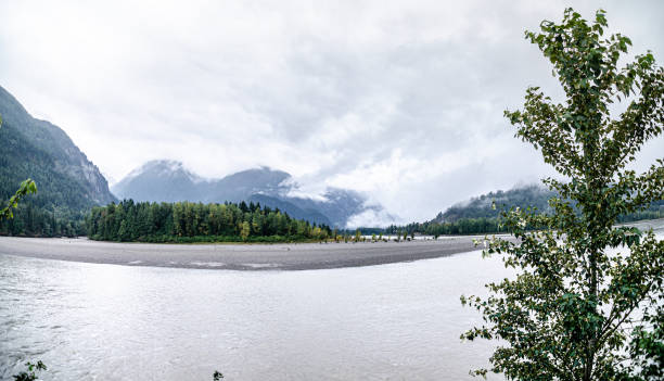 Fraser River with cloud covered green mountains in the background at Hope, BC, Canada