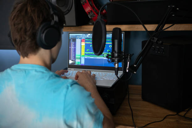 istock Young man producing music in his home recording music studio 2184490260