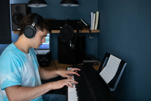 istock Young man producing music in his home recording music studio 2184490286