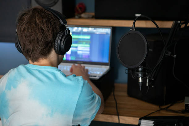 istock Young man producing music in his home recording music studio 2184490394
