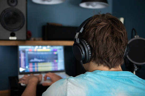 istock Young man producing music in his home recording music studio 2184490481